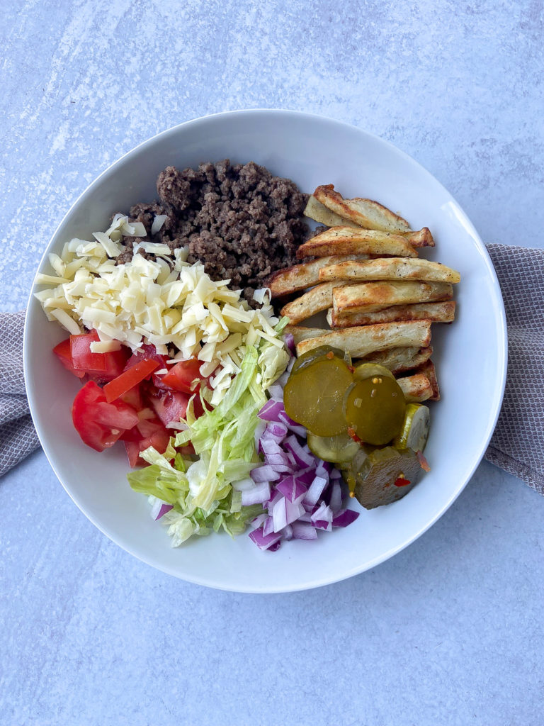 Ground beef and French fries in a bowl with toppings